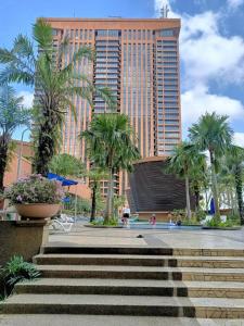 um grande edifício com palmeiras e escadas em frente em Urban Suite Times Square Kuala Lumpur em Kuala Lumpur