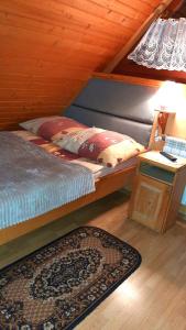 ザコパネにあるPokoje Goscinne Majerczykのベッドルーム1室(ベッド1台、ランプ付きテーブル付)