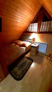 Habitación en el ático con cama y alfombra en Pokoje Goscinne Majerczyk, en Zakopane