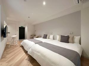 a large bedroom with a large white bed in it at bHOTEL Rijodori - Central City Studio Stay with Free Breakfast in Hiroshima