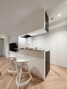 a kitchen with two stools and a counter in a room at bHOTEL Rijodori - Central City Studio Stay with Free Breakfast in Hiroshima