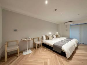 広島市にあるbHOTEL Rijodori - Complimentary Breakfast Included, City Central Studioのベッドルーム1室(大型ベッド1台、テーブル、椅子付)
