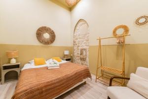 ein Schlafzimmer mit einem Bett mit orangefarbenen und gelben Kissen in der Unterkunft Charmant appartement moderne haut marais - 4P in Paris