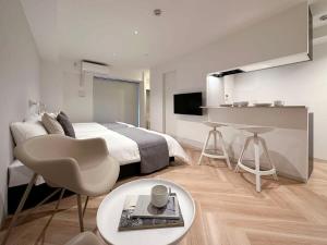 a bedroom with a bed and a table and a desk at b hotel Rijodori - City Central Studio Stay with Breakfast in Hiroshima