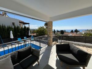uma varanda com 2 sofás e uma piscina em Villa Marina Sea-View Private Pool em Pegeia ou Pegya
