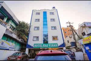 a tall white building with a sign in front of it at Hotel Raj vihar residency in Vijayawāda