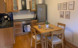 a kitchen with a wooden table with chairs and a refrigerator at Strandlägenhet Byxelkrok, Öland in Byxelkrok