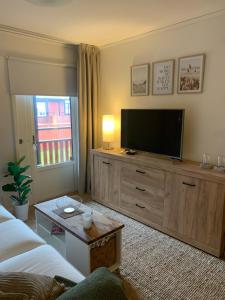 a living room with a television on a wooden dresser at Strandlägenhet Byxelkrok, Öland in Byxelkrok