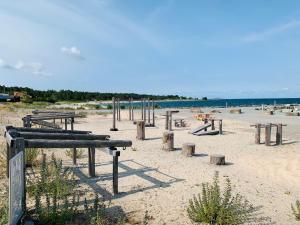 a playground on a beach with people on a surfboard at Strandlägenhet Byxelkrok, Öland in Byxelkrok