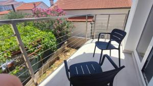 two chairs and a table on a balcony at Guesthouse - Hotel California in Novalja