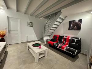 sala de estar con sofá rojo y mesa en L’ÉCURIE, en Gigny