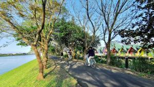 les personnes qui empruntent des vélos sur un sentier à côté de l'eau dans l'établissement Kitefarm, à Dongshan