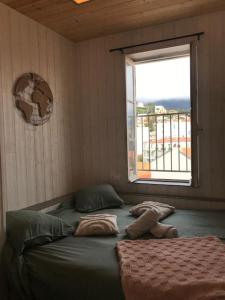 a bed in a room with a window at Lumineux studio sous les toits de Menton in Menton