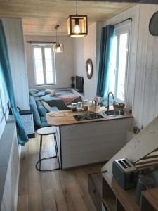 a kitchen and a living room with a couch at Lumineux studio sous les toits de Menton in Menton