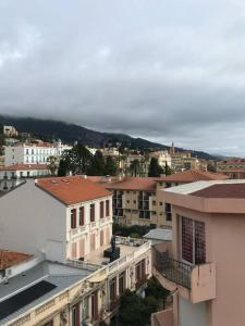 a view of a city with buildings and a mountain at Lumineux studio sous les toits de Menton in Menton