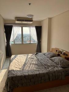 een slaapkamer met een bed en een groot raam bij Friendly Home @ Commonwealth in Bangkok