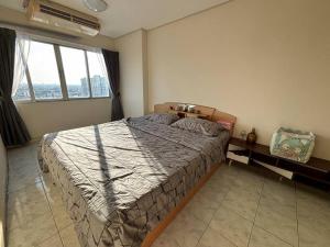 - une chambre avec un lit et une grande fenêtre dans l'établissement Friendly Home @ Commonwealth, à Bangkok