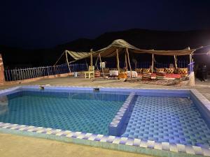 a swimming pool at night with a tent at Maison Les Grôttes in Aït Benhaddou