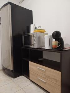 a black shelf with a microwave on top of it at Cameră privata cu baie Tina, Iulius Mall in Timişoara +7 photos