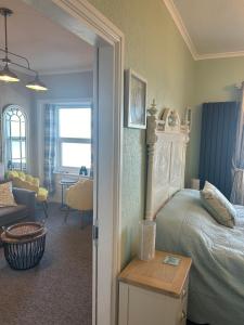 ein Schlafzimmer mit einem Bett und ein Wohnzimmer in der Unterkunft Glan Y Mor Hotel (Adult Only) in Llandudno