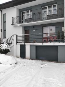 un edificio de apartamentos con nieve delante en Dom jednorodzinny, en Łapy