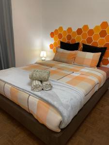 a large bed with an orange and white comforter at Barão 35 Guest House in Braga