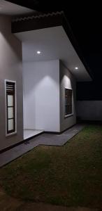 KadawataにあるArchie Homesの白い壁の客室で、窓が2つあります。