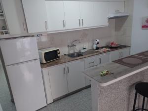 una cucina con frigorifero bianco e forno a microonde di Vivienda Vacacional a 50 Metros de la Playa a Puerto de Santiago