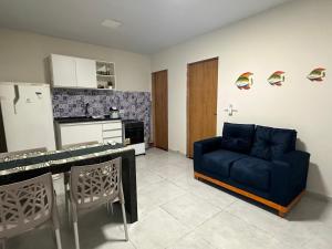 een woonkamer met een blauwe bank en een keuken bij Bela Beach in São José da Coroa Grande