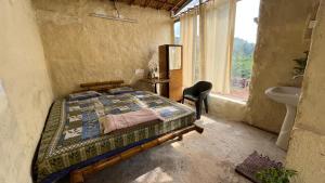 a bedroom with a bed and a sink and a window at 101 wake park in Mandrem