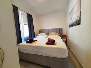 a bedroom with a bed with two towels on it at 1 Haus Linden Osljak in Island Osljak