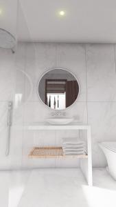 a white bathroom with a mirror and a sink at Sidari Waterpark in Sidari