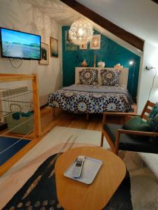 Cette chambre comprend un lit, une table et une télévision. dans l'établissement La Suite 27 bis, duplex indépendant, à Guingamp
