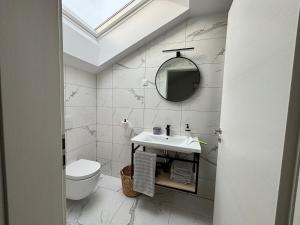 a white bathroom with a sink and a mirror at Apartmaji Čepon in Ljubljana