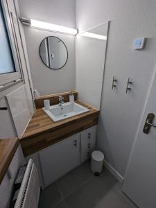 uma pequena casa de banho com um lavatório e um espelho em St Gilles Appartement face mer em Saint-Hilaire-de-Riez