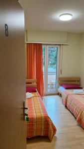 una camera con due letti e una porta con finestra di Ristorante Dosso a Sigirino