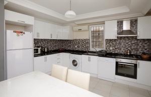 a kitchen with white appliances and a white table at Villa Raya2 in Fethiye