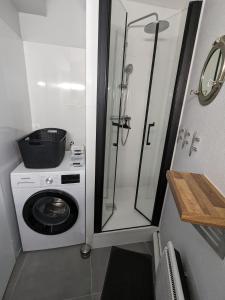 uma casa de banho com uma máquina de lavar roupa e um chuveiro em St Gilles Appartement face mer em Saint-Hilaire-de-Riez