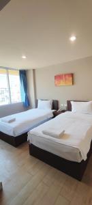two beds in a hotel room with at The Sea Bangsaen Hotel in Ban Bang Saen (1)