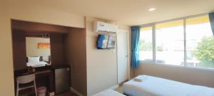 a small room with a bed and a window at The Sea Bangsaen Hotel in Ban Bang Saen (1)