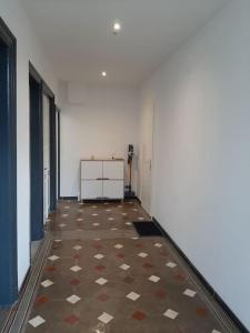 pusty korytarz z podłogą wyłożoną kafelkami w pokoju w obiekcie Chambre privée Au pied des Vosges w mieście Remiremont
