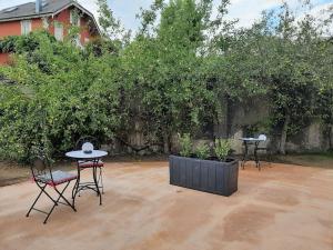 two chairs and a table and two tables in a yard at Chambre privée Au pied des Vosges in Remiremont