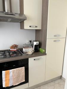 a kitchen with a stove and white cabinets at Casa di Giulia in Viterbo