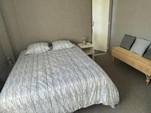 a bedroom with a large bed and a couch at Appartement OMAHA BEACH in Saint-Laurent-sur-Mer