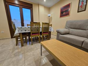 un soggiorno con divano, tavolo e sedie di Vivienda familiar y apartamentos RURALES LA BRAÑELA a Tapia de Casariego