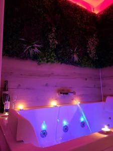 d'une baignoire blanche avec des lumières sur une table. dans l'établissement Le Parc, logement de charme avec SPA privatif - LE HAVRE, au Havre