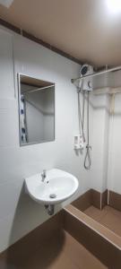a bathroom with a white sink and a mirror at The Sea Bangsaen Hotel in Ban Bang Saen (1)