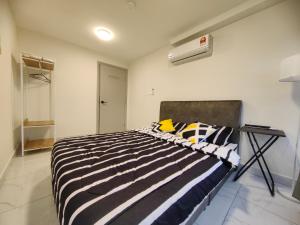 a bedroom with a black and white striped bed at Arte Cheras Duplex Suites in Kuala Lumpur