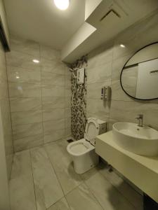 a bathroom with a sink and a toilet and a mirror at Arte Cheras Duplex Suites in Kuala Lumpur