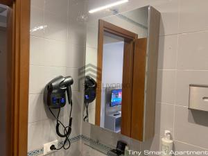 a mirror in a bathroom with a hair dryer at Suites Marilia Apartments - Suite Livorno Holiday Home Group in Livorno